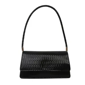 Borsa a spalla nera lucida con texture ondulata e dettagli in metallo dorato chic