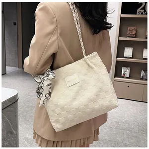 Vue détaillée du sac cabas tissé blanc cassé avec foulard en soie porté par un mannequin