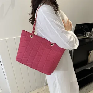 Quilted rose red tote bag with gold chain strap shown on model for daily casual style