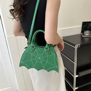 Green crossbody bag with white spider web print and bat wing shape for women