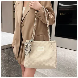 Détail du sac cabas crème tressé en damier avec foulard en soie et anses tressées