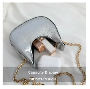 Silver crescent bag capacity detail showing storage for lipstick and wireless earbuds