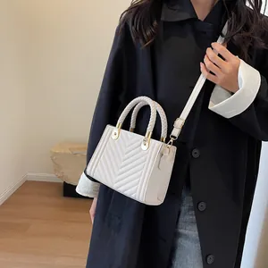Chic white crossbody bag with V-quilted pattern and braided handles for stylish women