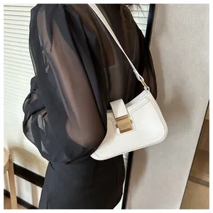 Dettaglio borsa sottobraccio bianca in ecopelle con chiusura dorata su top nero