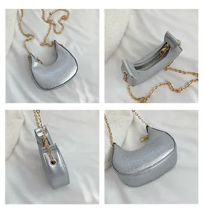 Detailed views of a silver crescent bag featuring snake texture and gold chain strap