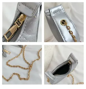 Close-up of silver crescent bag detailing fish scale texture and gold chain hardware