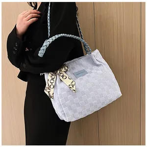 Détail d'un grand sac cabas bleu clair avec foulard en soie et poignée tressée