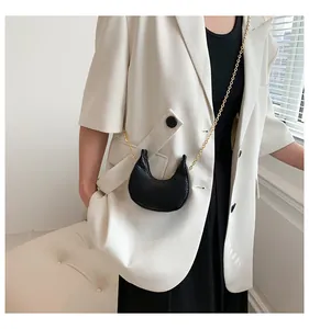 Detailed view of black crocodile pattern crescent mini bag with golden metal chain strap