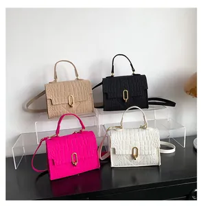 Detail view of four textured crocodile pattern crossbody bags in black, white, pink and khaki