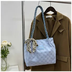 Détail du sac fourre-tout matelassé bleu clair avec texture tissée et foulard décoratif