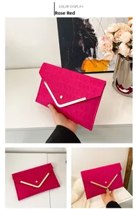 Detail view of rose red envelope clutch featuring crocodile pattern and gold V-metal trim