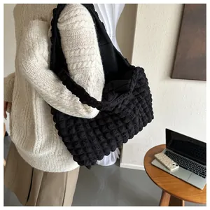 Detail of black popcorn texture tote bag with minimalist shoulder strap design