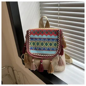 Close-up of ethnic canvas backpack with colorful geometric embroidery and silk tassels
