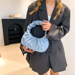 Minimalist light blue pleated hobo bag for women worn with an oversized grey blazer