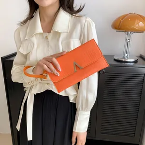Orange faux-crocodile leather envelope clutch bag with gold V hardware and wrist strap