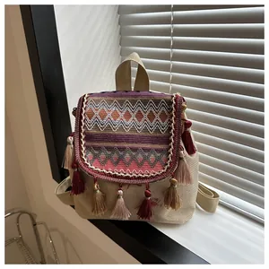 Detail of bohemian canvas backpack with colorful geometric patterns and long fringes