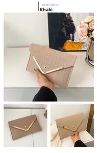 Detail of khaki crocodile pattern envelope clutch with V-shaped gold metal trim