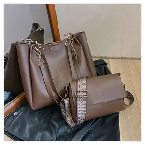 Detail of brown leather tote and crossbody bag set with patterned fabric strap and chain