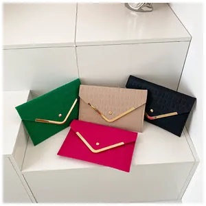 Detailed display of crocodile pattern envelope clutches with V-shaped metal gold trim
