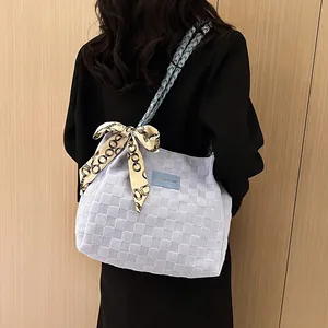 Sac fourre-tout bleu clair texturé avec bandoulière tressée porté par un mannequin