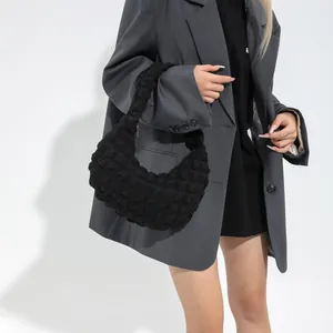 Sac à main noir texturé à bulles avec un design minimaliste en forme de croissant