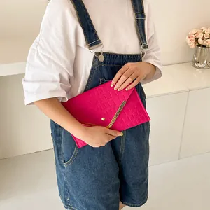 Magenta envelope clutch bag with crocodile texture and V-shaped gold metal trim