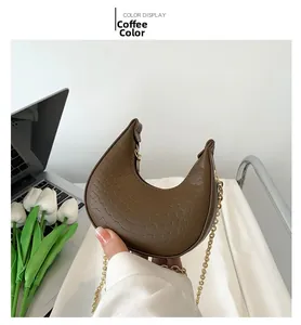Detail of coffee brown crescent bag featuring crocodile texture and gold chain strap