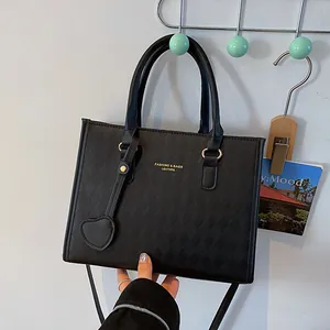 Classic black quilted leather handbag with gold hardware and a heart-shaped charm accessory