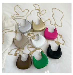 Flat lay of mini crescent crossbody bags in eight colors with crocodile texture and chains