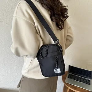 Minimalist black square crossbody bag with 'Hello Weekend' patch and adjustable strap