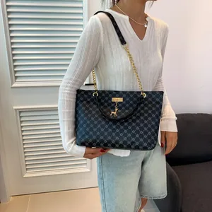 Large tote bag with star pattern print and gold chain strap shown on a model