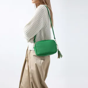 Stylish green pebbled leather crossbody camera bag with tassel detail and gold zipper