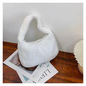 Détail de la texture en peluche blanche douce et de la poignée en fausse fourrure du sac carré