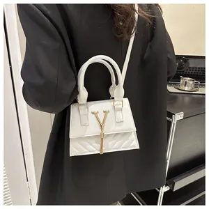 Détail du sac à bandoulière en cuir blanc montrant le matelassage en V et le logo doré