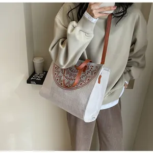 Detail of canvas tote bag with tribal pattern, leather straps and adjustable shoulder strap