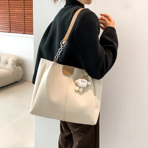 Beige tote bag with brown straps and plush charm, stylish large capacity shoulder bag
