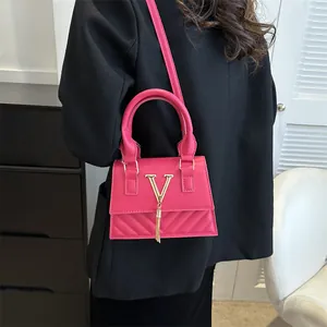 Sac bandoulière rose fuchsia vintage avec logo V doré et détails de franges stylés