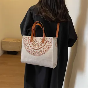 Bohemian canvas tote bag with geometric print and brown leather straps on model