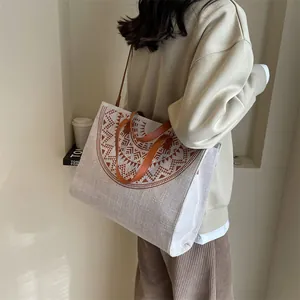 Retro canvas tote bag with brown geometric pattern and leather straps shown on model
