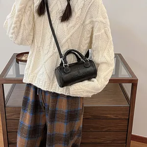 Borsa a mano Boston nera minimalista con scritte in rilievo e tracolla regolabile