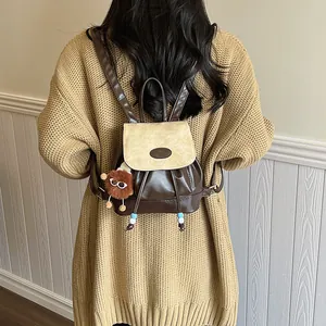 Women's minimalist two-tone mini backpack in brown and beige with plush charm