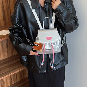 Chic silver mini travel backpack for women with plush charm and pink fashion plate