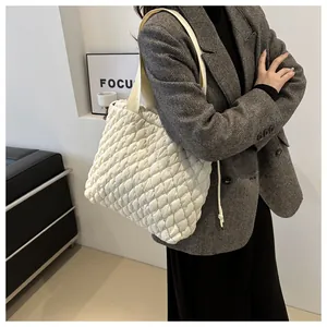 Minimalist white quilted puff tote bag with comfortable wide shoulder strap on a model