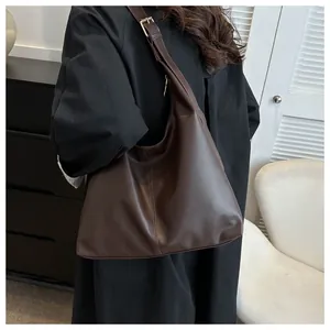 Deep brown large capacity PU leather tote bag with adjustable wide strap on a shoulder