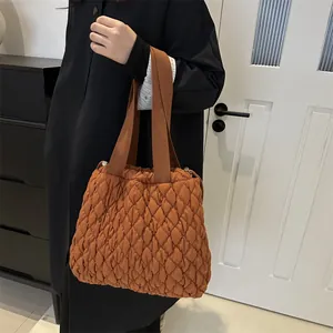 Quilted brown tote bag with puffer design and wide handles for casual commuting