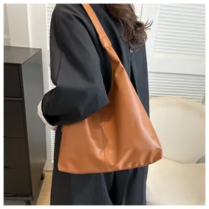 Detailed side view of a brown soft leather tote bag showing texture and stitching