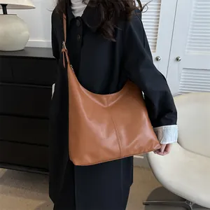 Brown leather large tote bag with vertical stitching and adjustable shoulder strap