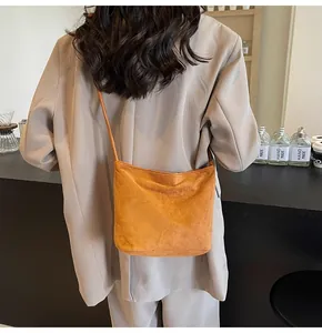 Gros plan du sac seau orange gingembre en daim avec lettrage en relief élégant