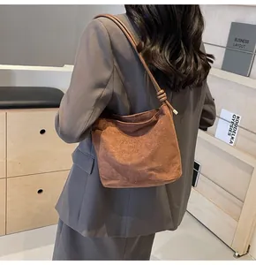 Détail du sac seau marron avec texte Fashion and Sunday et bandoulière à nœud