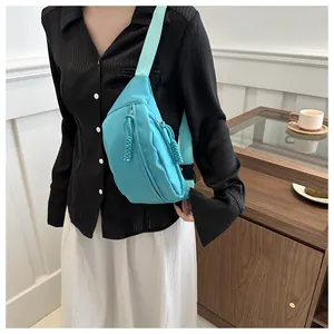 Detail van een turquoise nylon heuptas met verstelbare riem en zwarte plastic gespsluiting